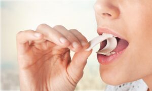 donna inserisce gomma da masticare in bocca